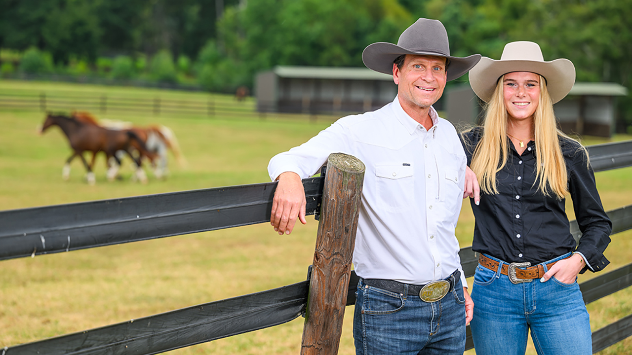 John and Blake Park standing in front of a horse field