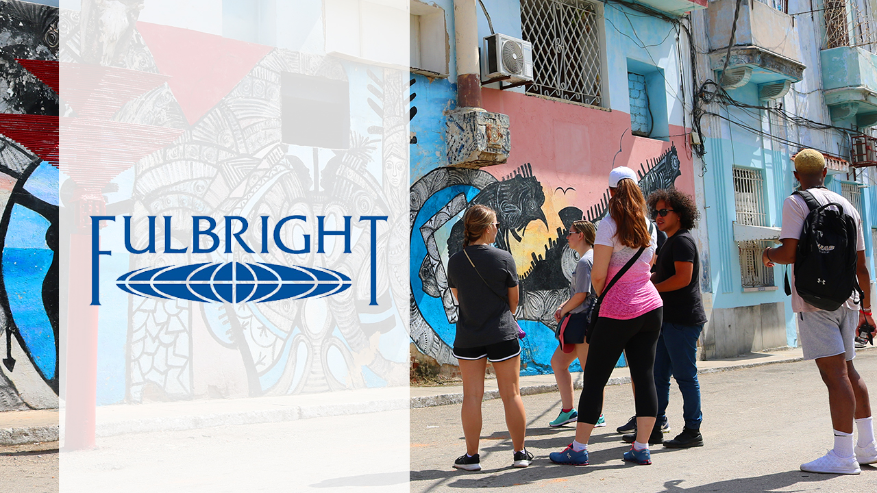 Students traveling abroad looking at art on wall with fulbright logo on a white background