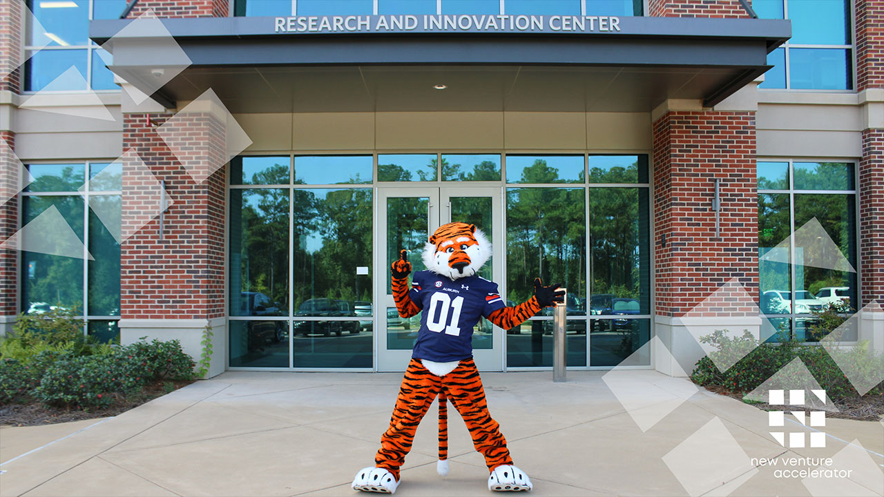 Aubie stands in front of the Research and Innovation Center building.