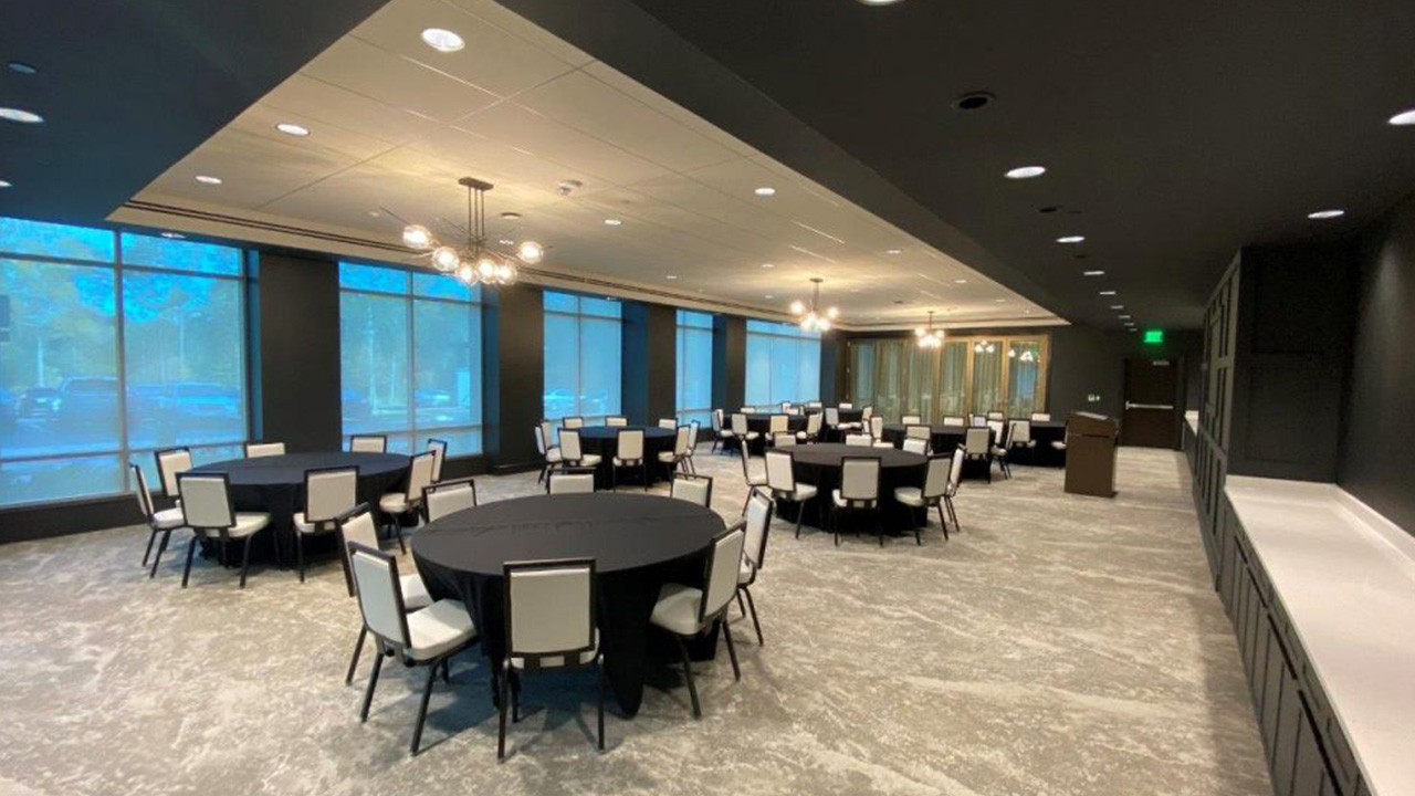 An image of round tables and chairs in a large meeting or event space. 