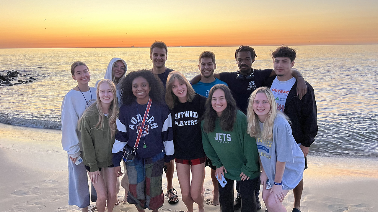 Student gathered on beach near ocean