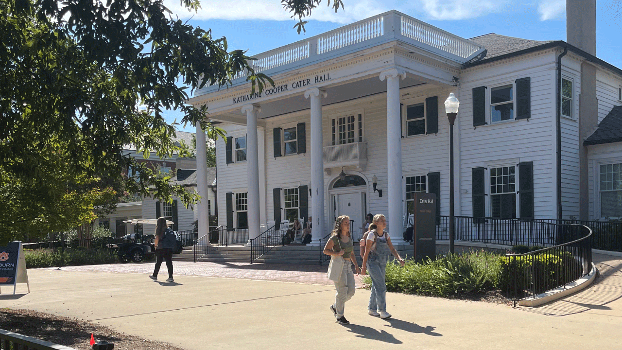 students walking past Cater Hall on a warm day