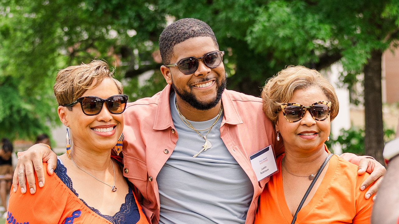 Three Black alumni posing for a picture. 