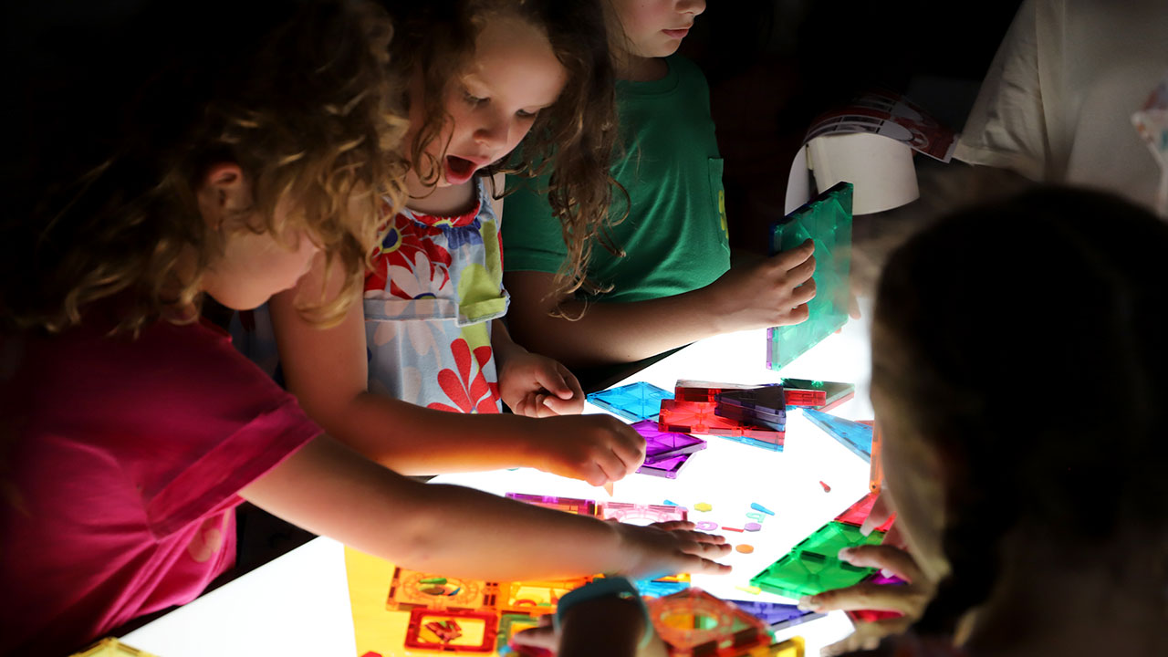 Children have fun working with colorful artwork as part of the Auburn Early Childhood Education summer enrichment program.
