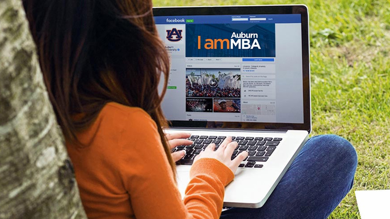 Online MBA student typing on laptop.