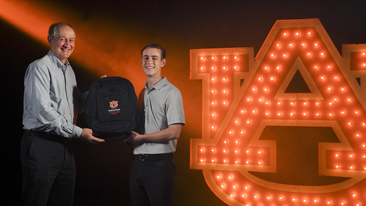 David Paradice presents backpack to Paradice Analytics scholar winner