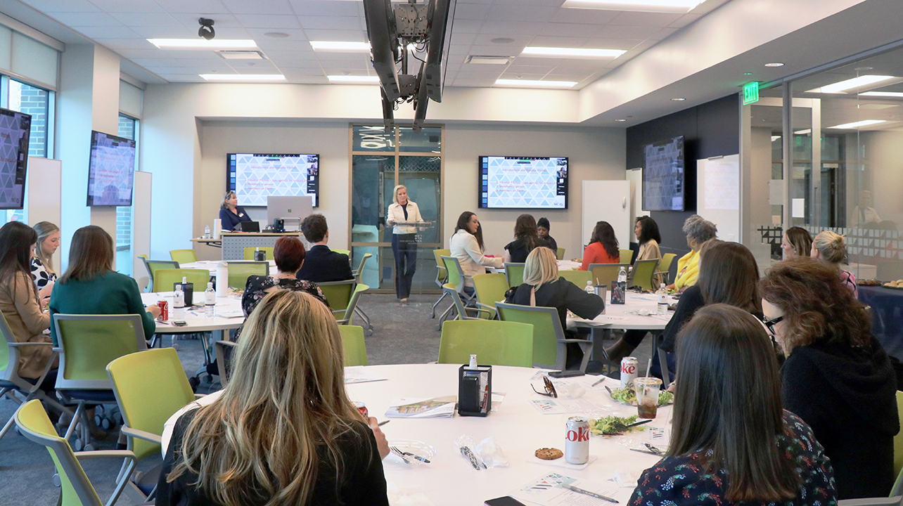 Woman entrepreneur speaking to room full of aspiring entrepreneurs