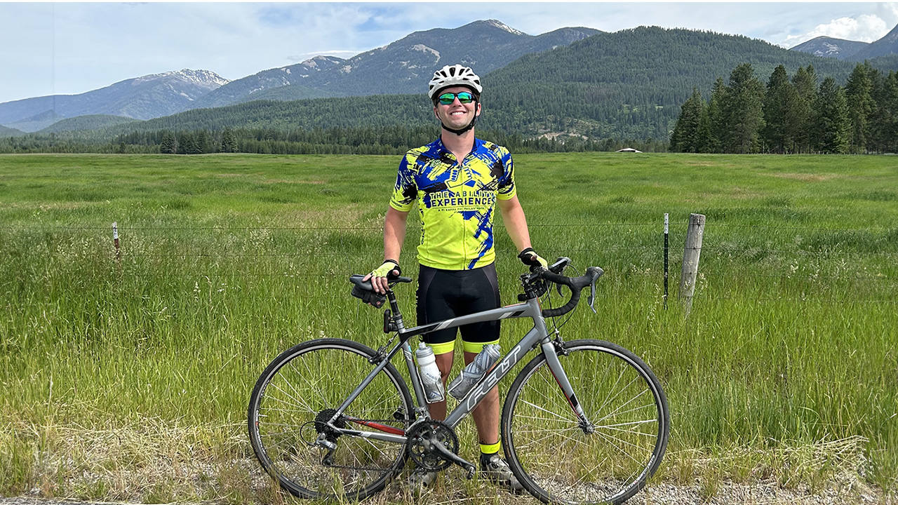 Man standing with bike and mountains in background
