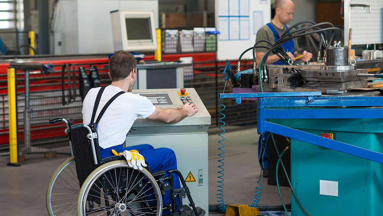 Manufacturing employee in wheel chair working 