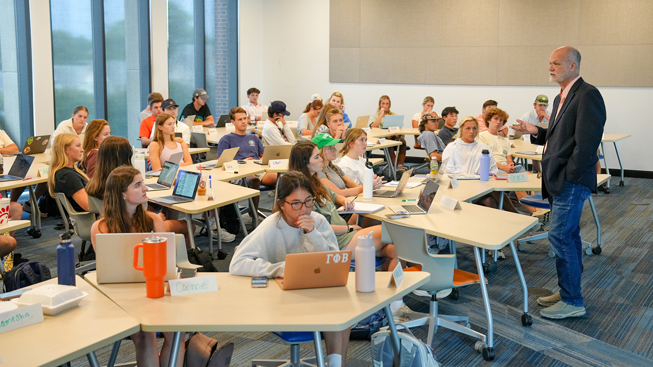 Male professor teaching students in classroom