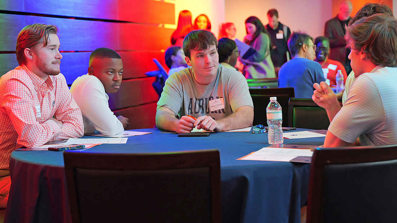 Four students at table discuss new business ideas