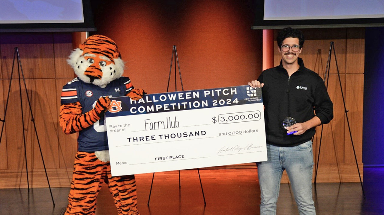 Student holding big check with Aubie mascot