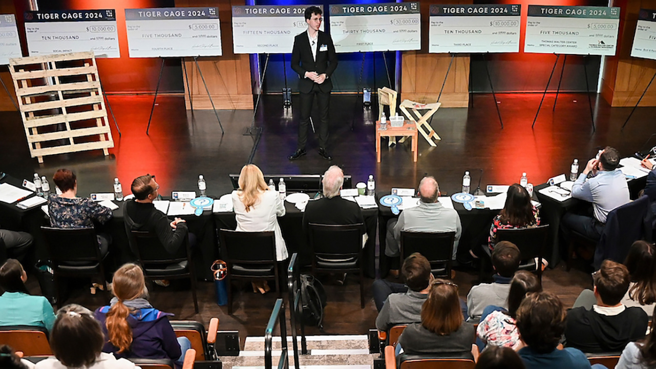 Student presenting business pitch to judges and audience