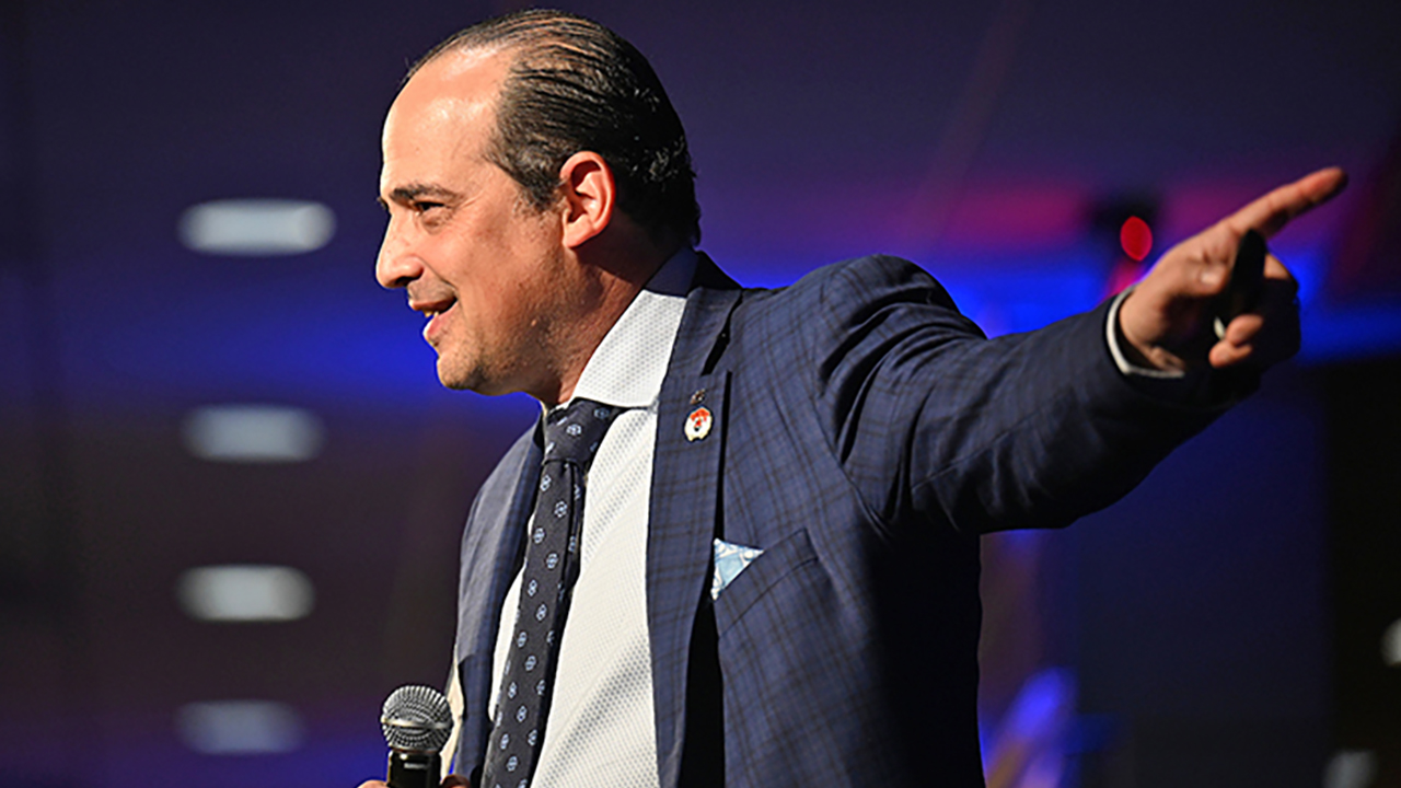 Speaker Spencer Levy holding microphone