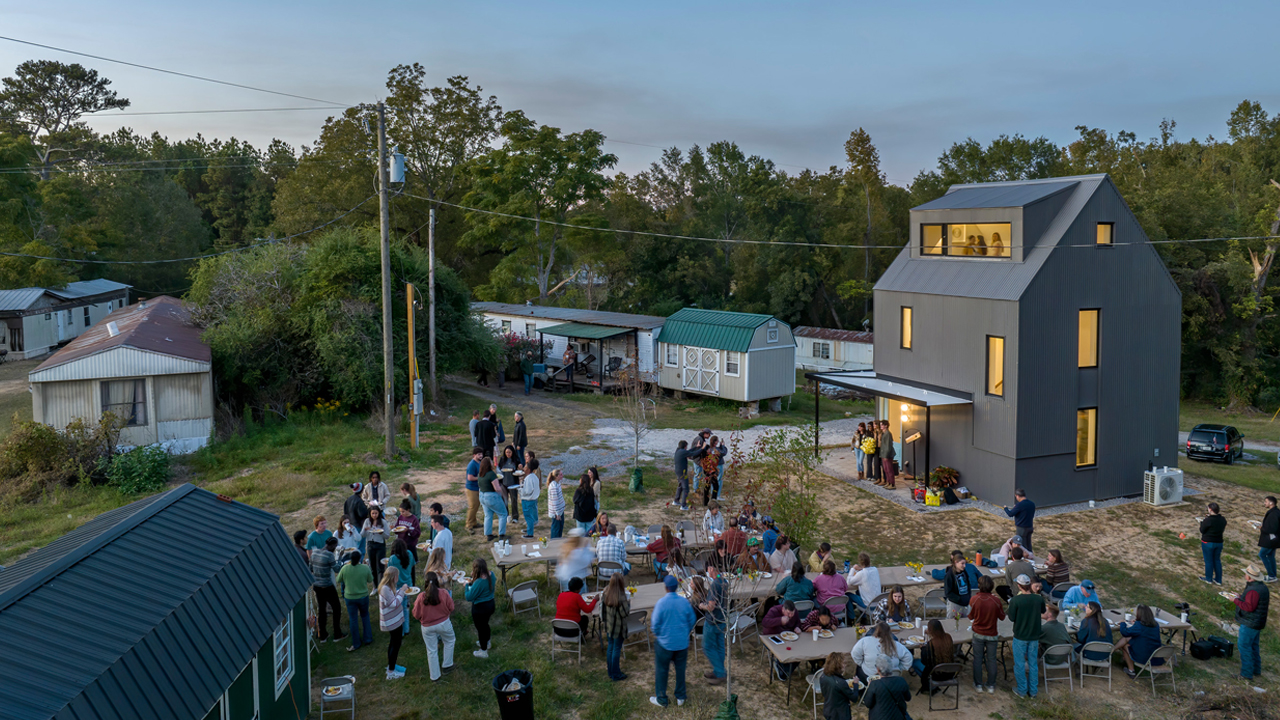 Students and community members gather outside the newly built home