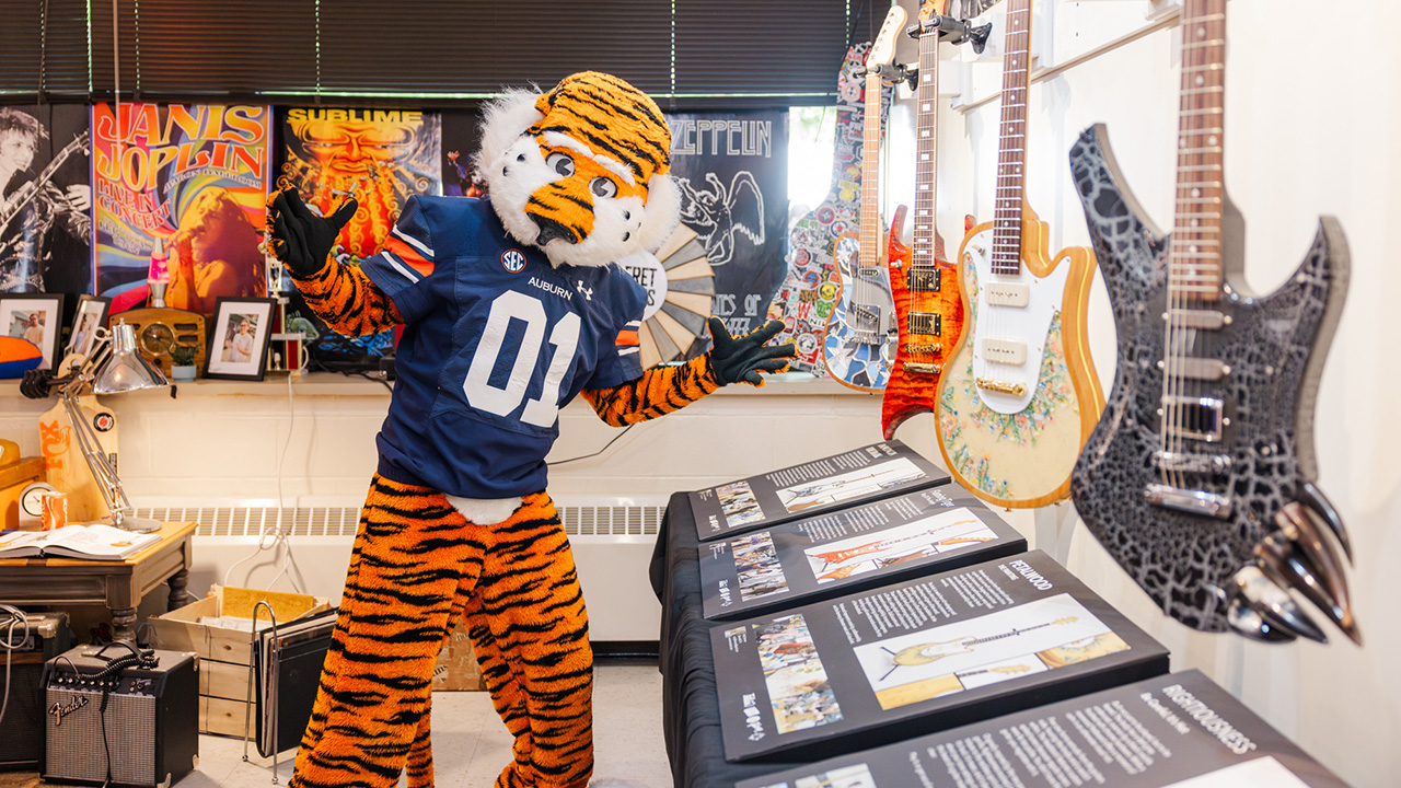 Aubie poses with Frethaus guitars at the 2025 Kaleidoscope Show 