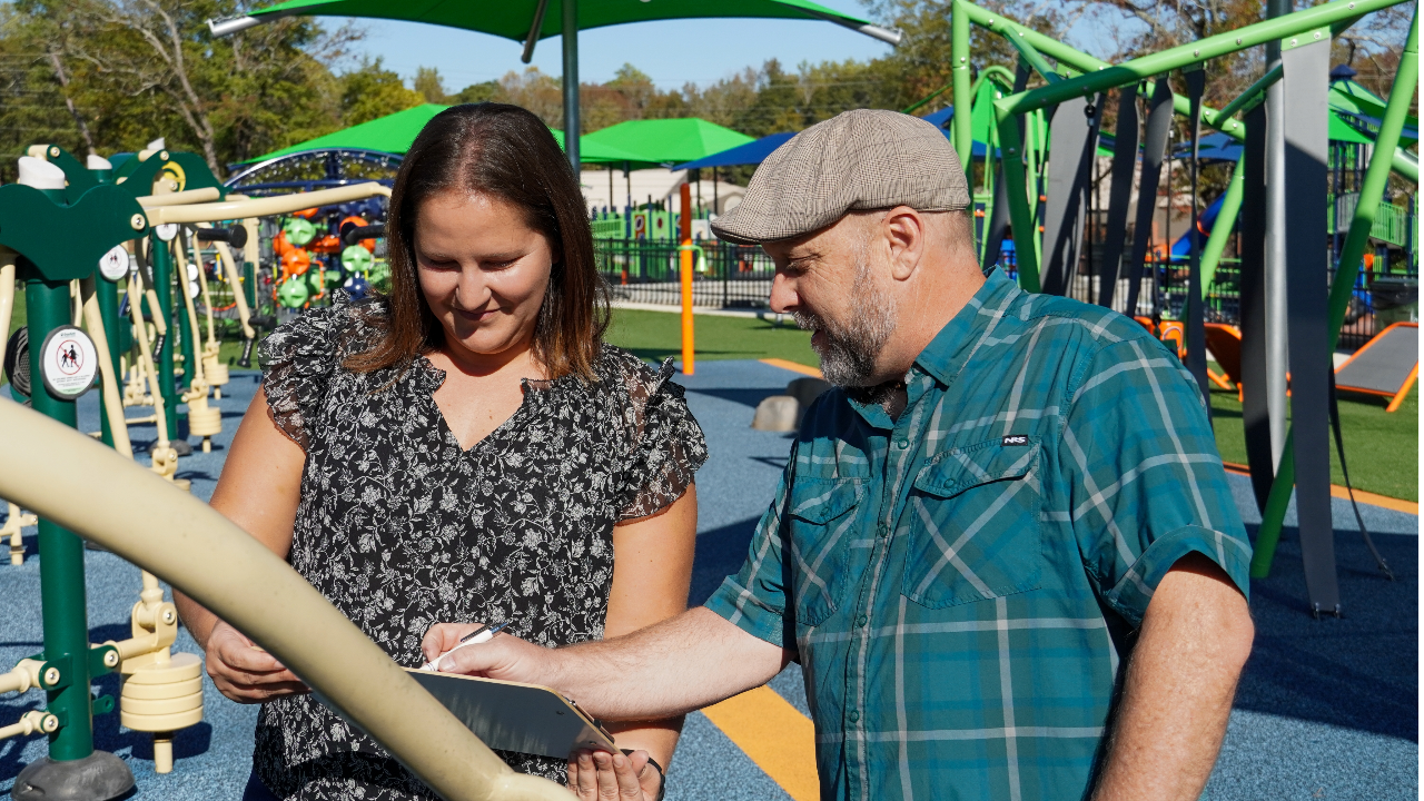 Morse and McCreary examine a piece of accessible play equipment at the City of Auburn’s new Town Creek accessible playground