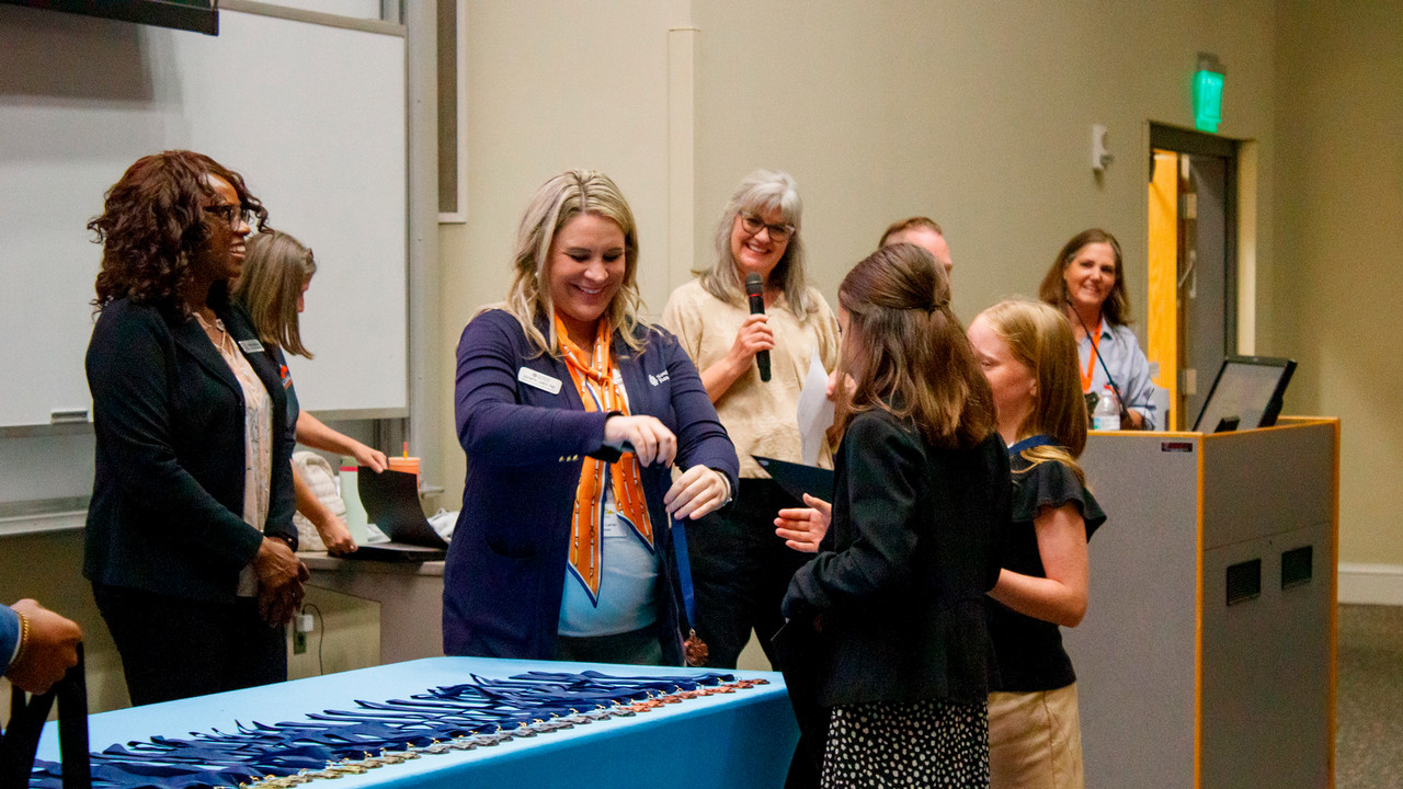 A woman hands out medals