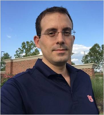 headshot of auburn computational chemist Evangelos Miliordos wearing a navy polo with an orange interlocking AU