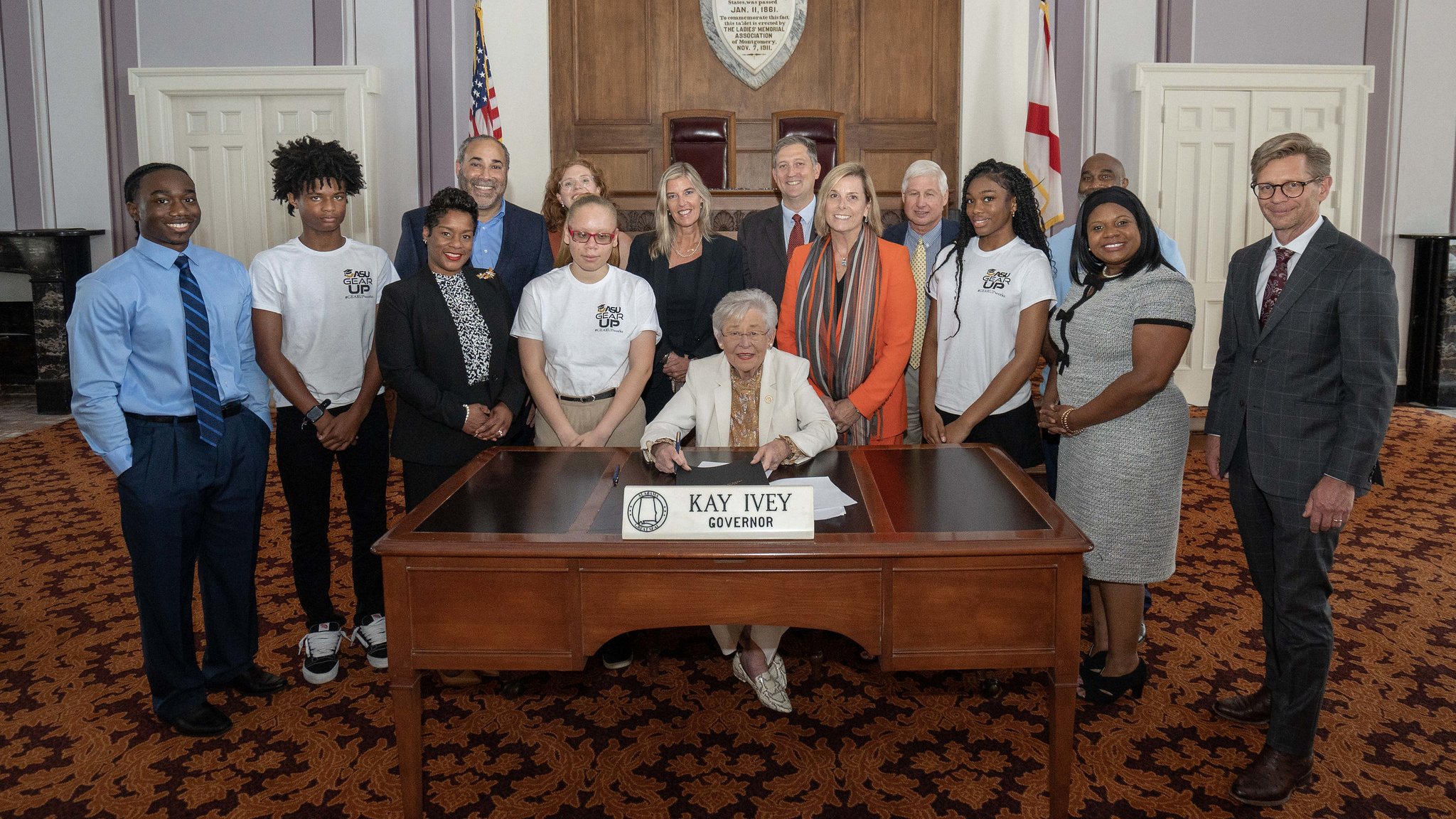 Alabama Governor Kay Ivey signs a proclamation declaring National GEAR UP Week in the state surrounded by representatives from GEAR UP Achieve, GEAR UP Jefferson County and ASU GEAR UP.