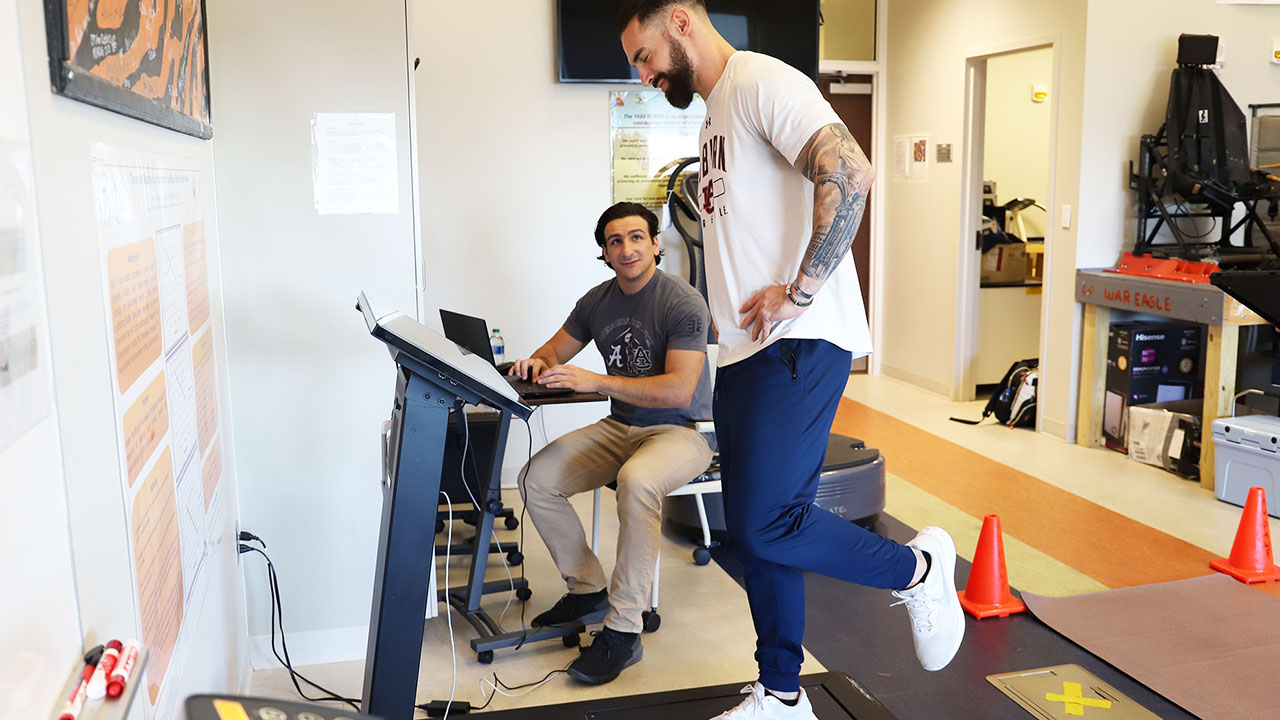 A physical therapist works with an athlete in a lab.