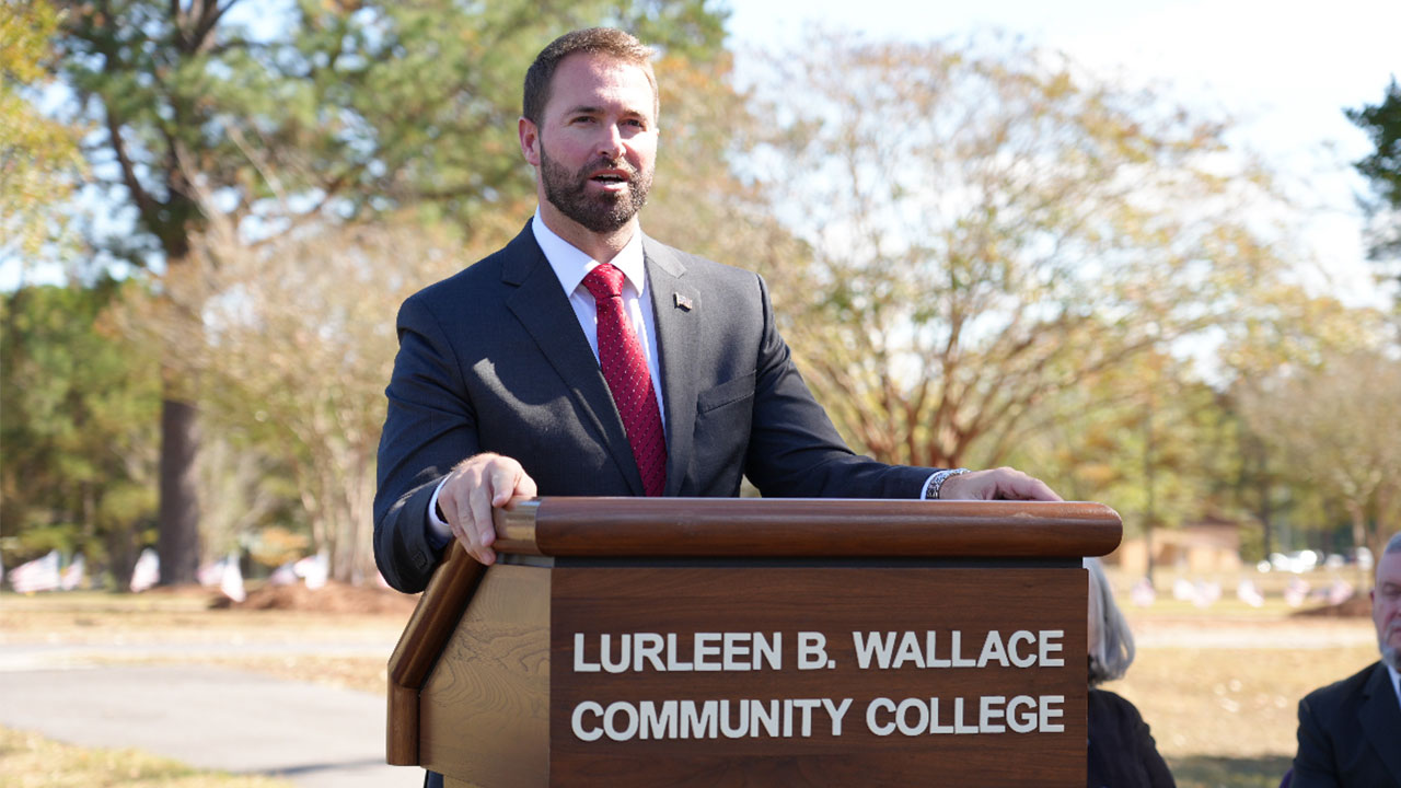 Brock Kelley is pictured at a podium speaking outdoors