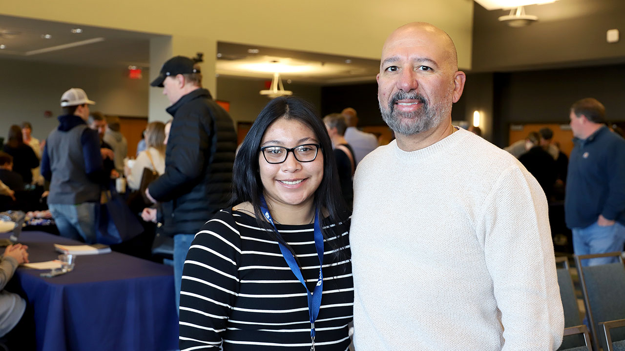 Sophia Corliss and her father pose for a photo indoors.