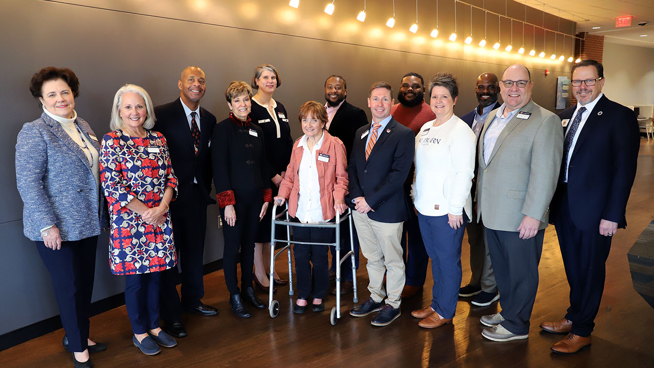 A group of College of Education alumni pose for a photo indoors.