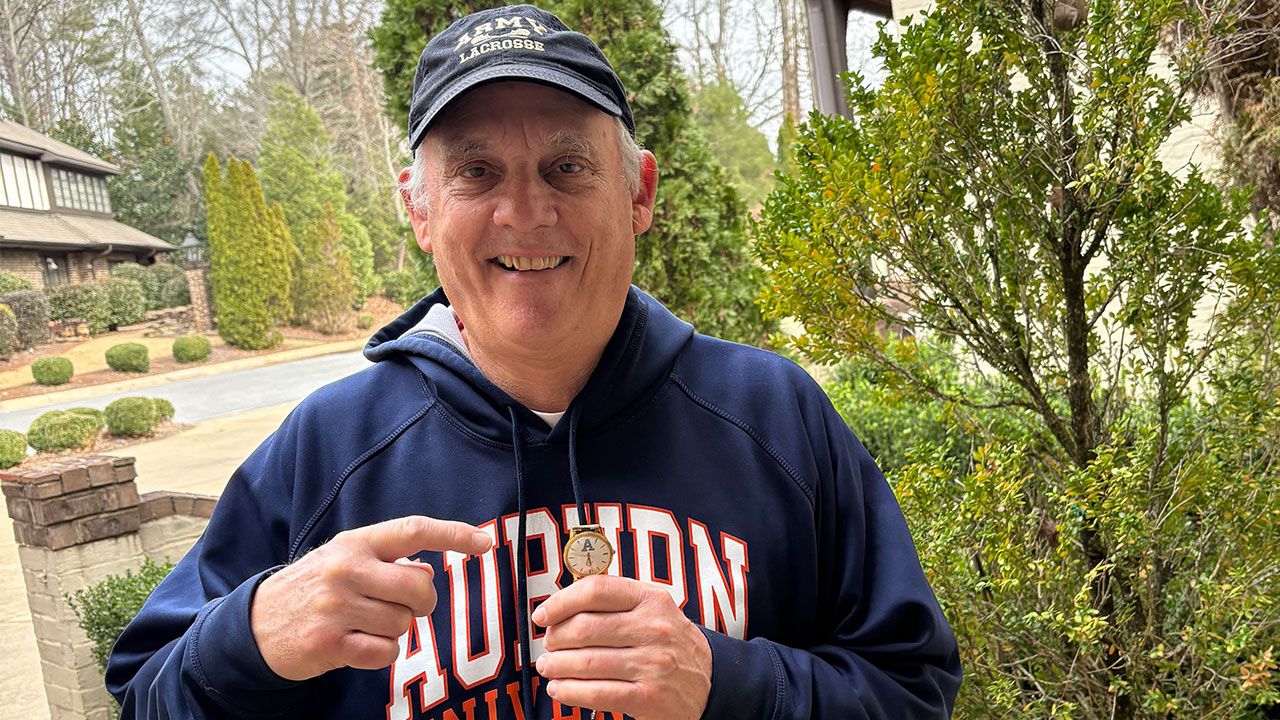 Greg Doepke is pictured holding his old Army lacrossed watch that was lost 50 years ago.