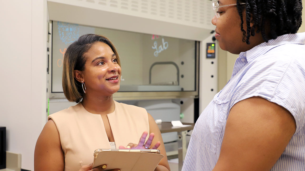 Evelyn Hunter is pictured holding an iPad and talking to a patient