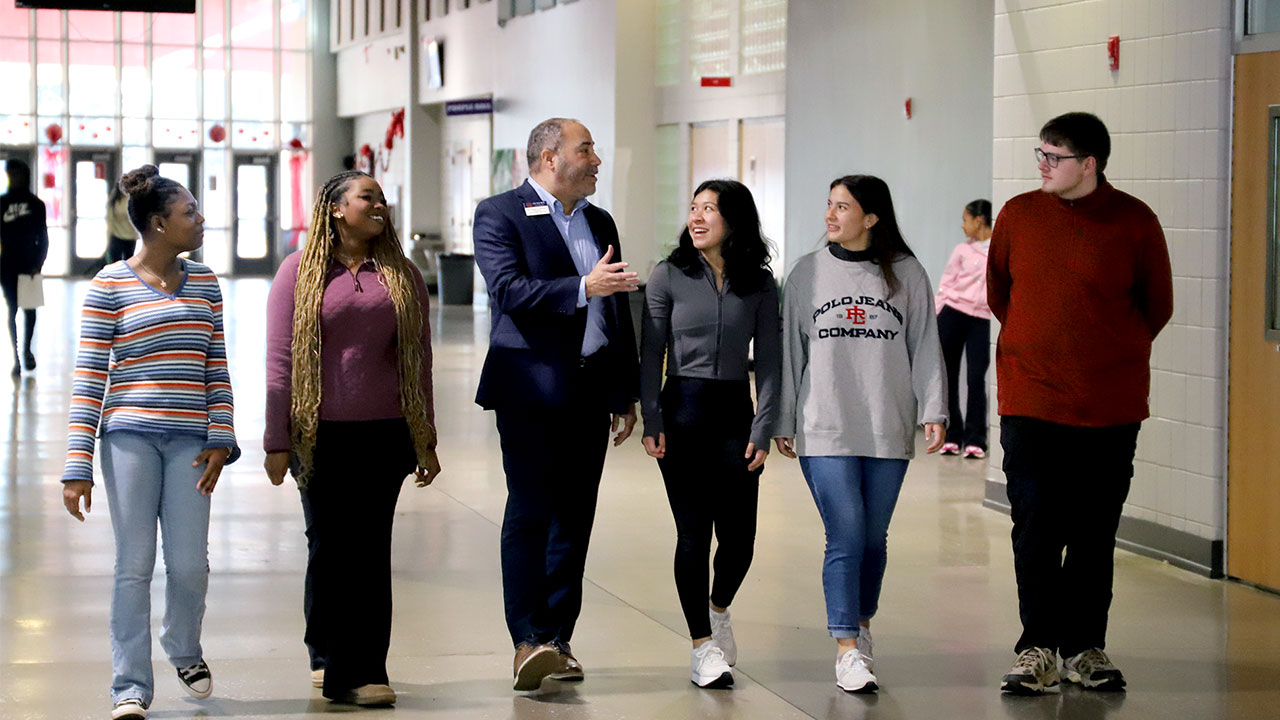Jason Bryant walks with a group of students inside Opelika High School.