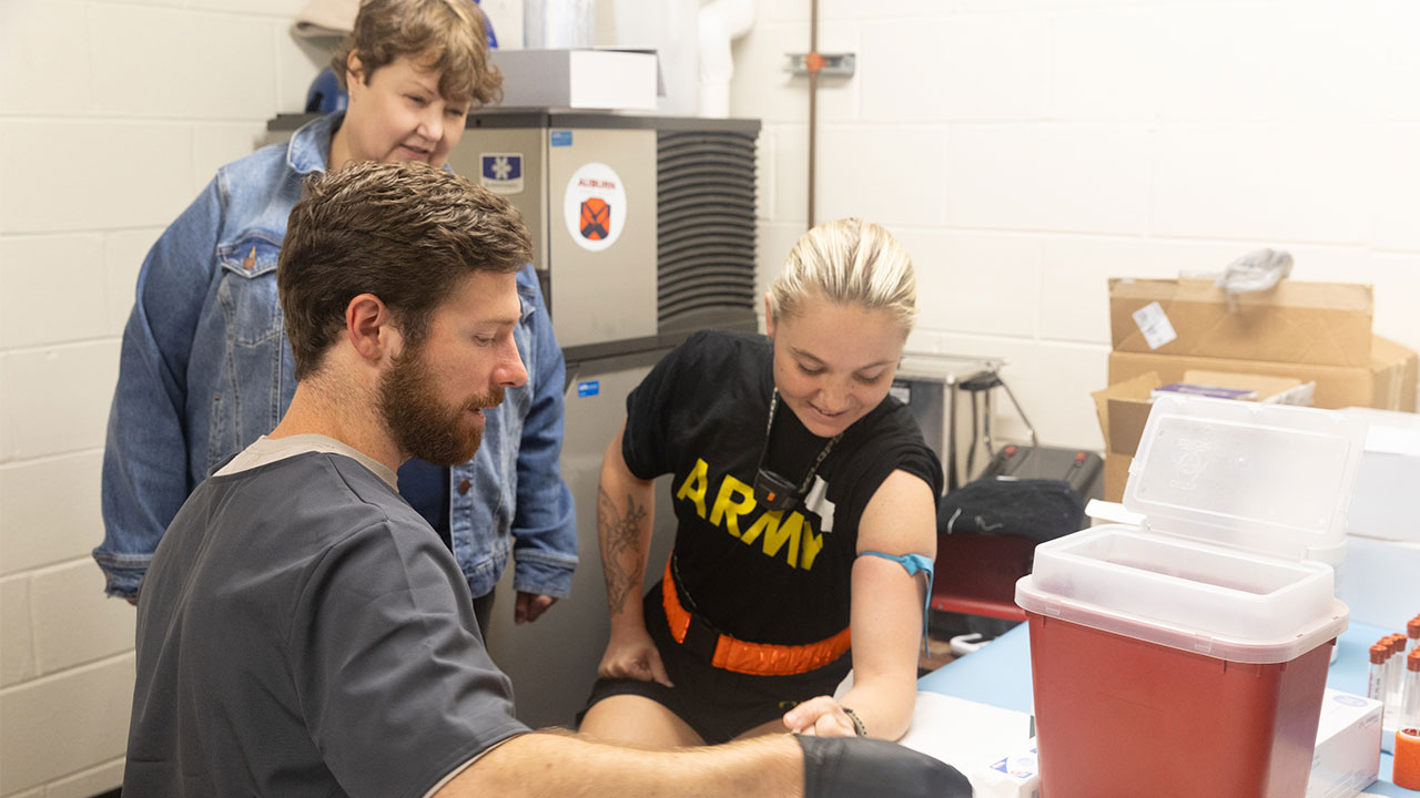Joellen Sefton is pictured with two other people in a lab setting.