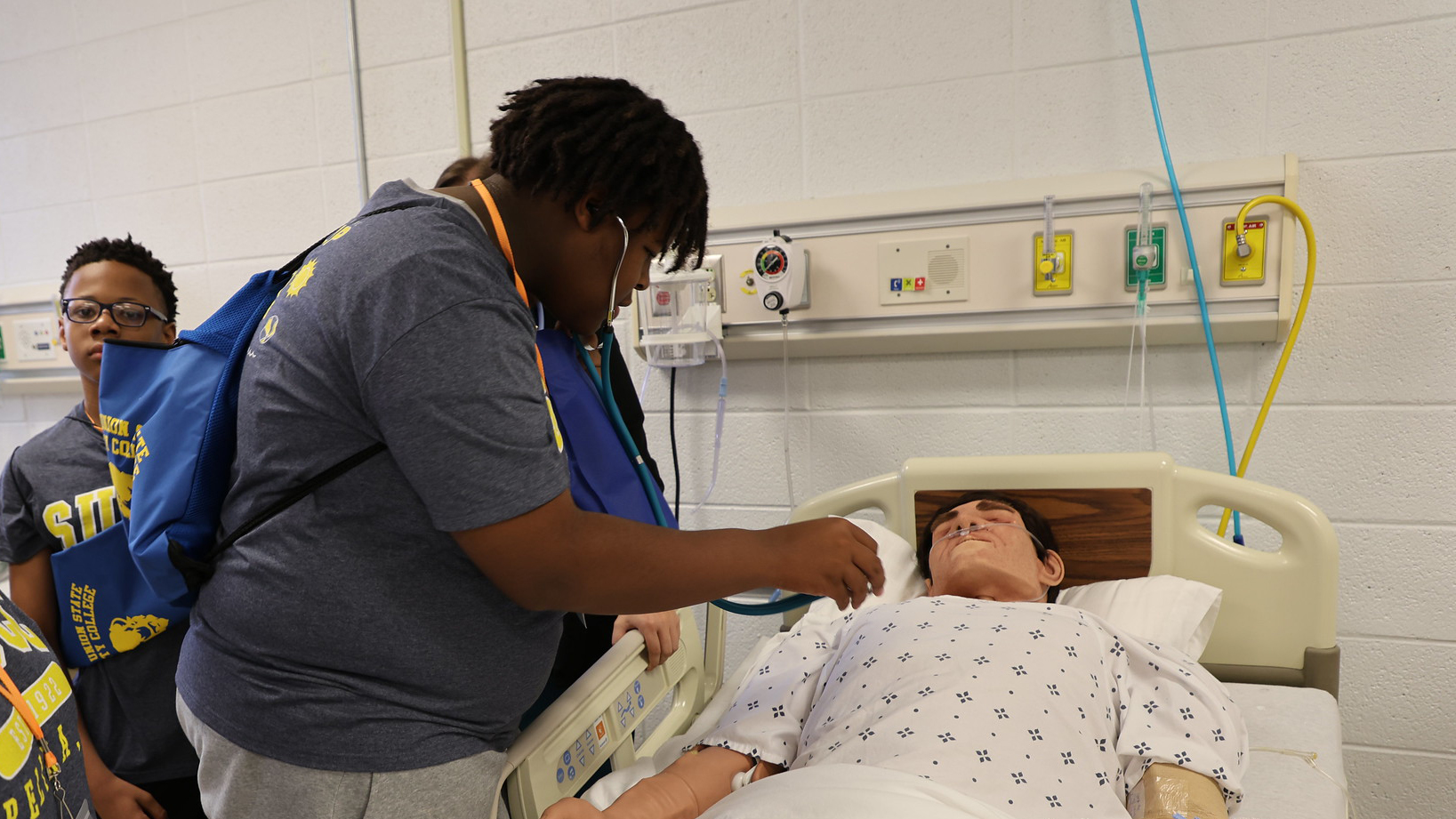 Jessean Patterson takes a turn with a stethoscope, listening for a mannequin patient's heartbeat as part of a tour of Southern Union State Community College's Health Sciences Laboratories.