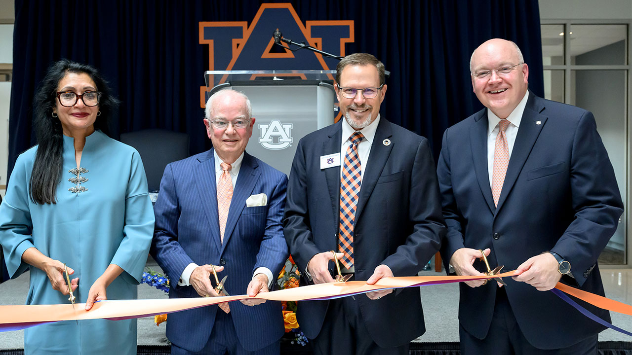Four Auburn leaders cut a ribbon as part of the grand opening ceremony for the College of Education's new building.