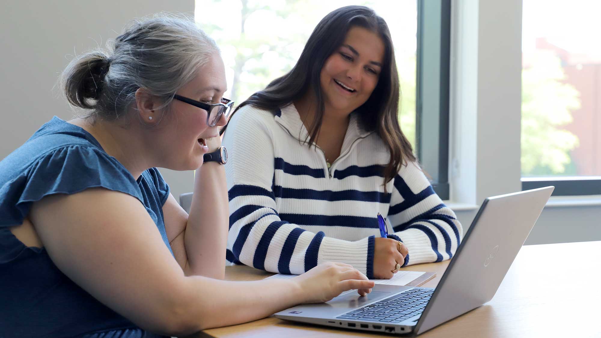 Jennie Baumann looking at a computer with her student