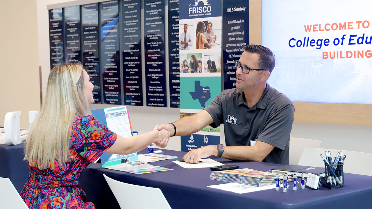 A student speaks with a school district representative inside the College of Education building as part of the Fall Education Interview Day event.