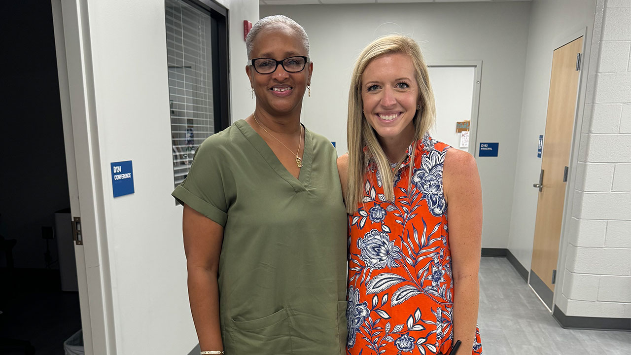 Beverly Price, pictured left, and Kathryn Conradson stand next to one another smiling for a photo.