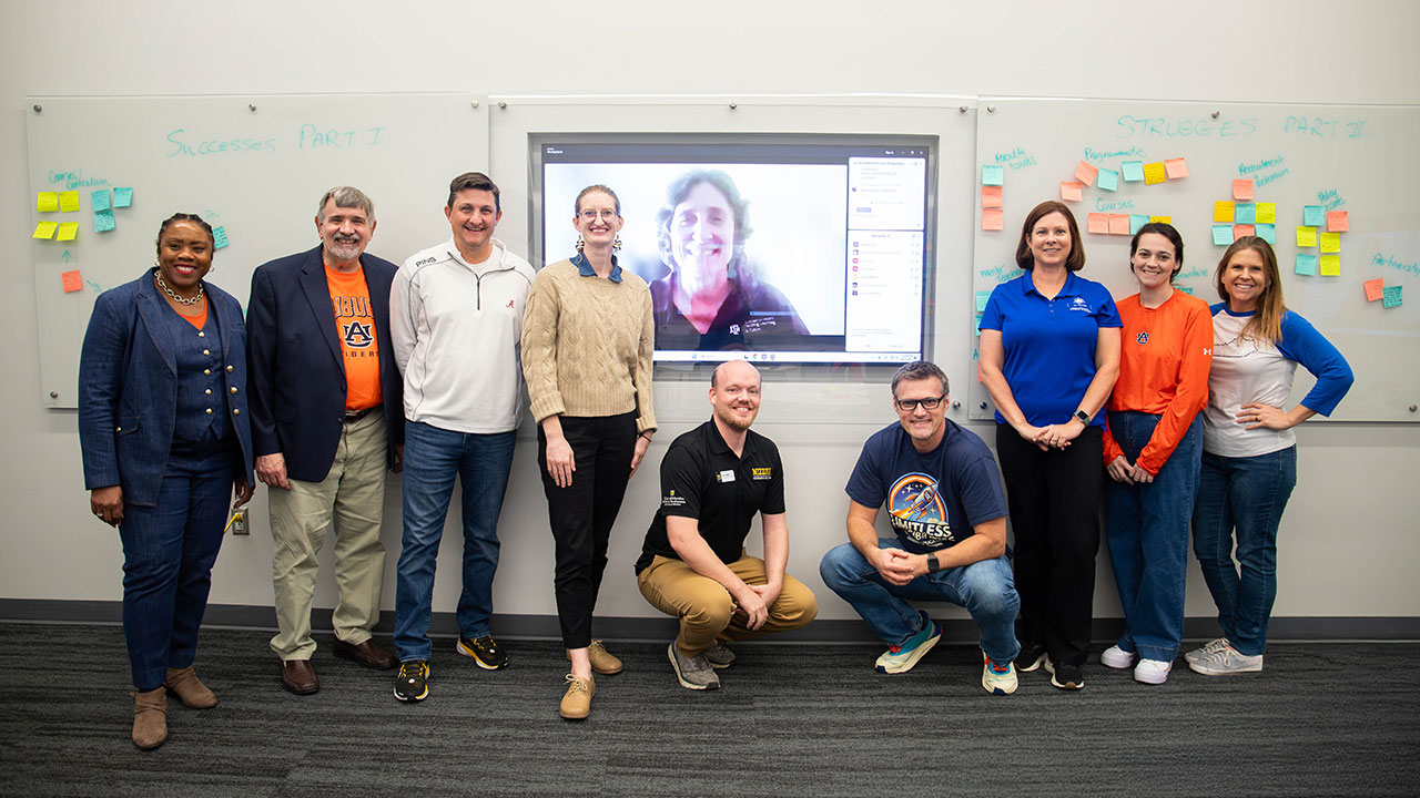 Mathematics Education faculty members from the SEC are pictured inside a room in the new College of Education building. One faculty member is pictured on a TV screen while joining remotely.