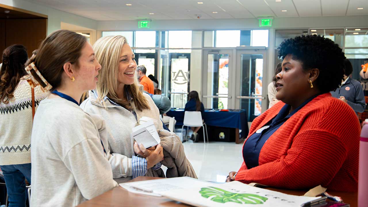 A prospective student and her mom speaking to a college faculty member