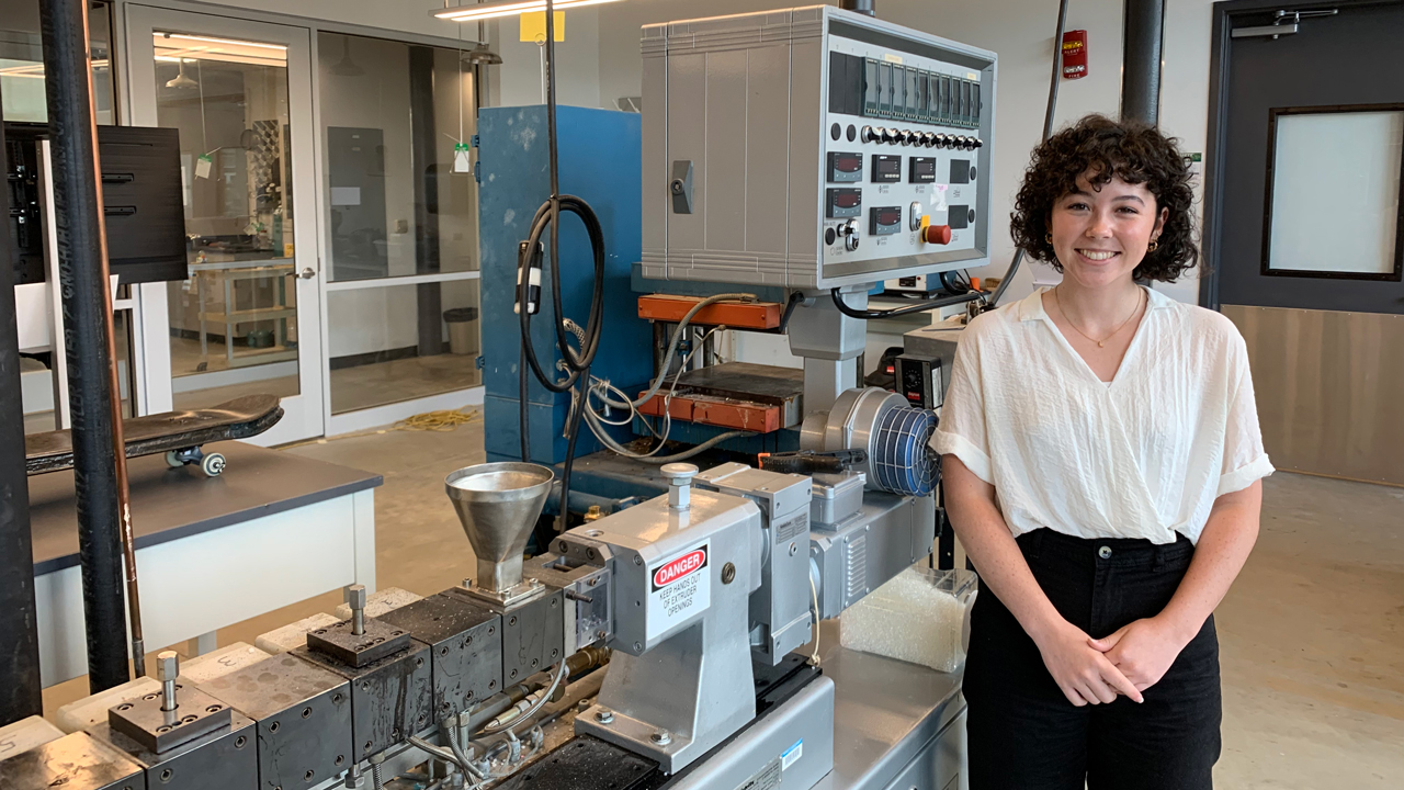 Maggie Nelson stands in front of a lab table full of research materials