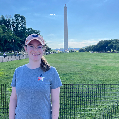 Ashley in Auburn baseball hat standing in front of the washington momument