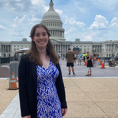 Ashley in a blue dress standing in front of the capitol building in dc