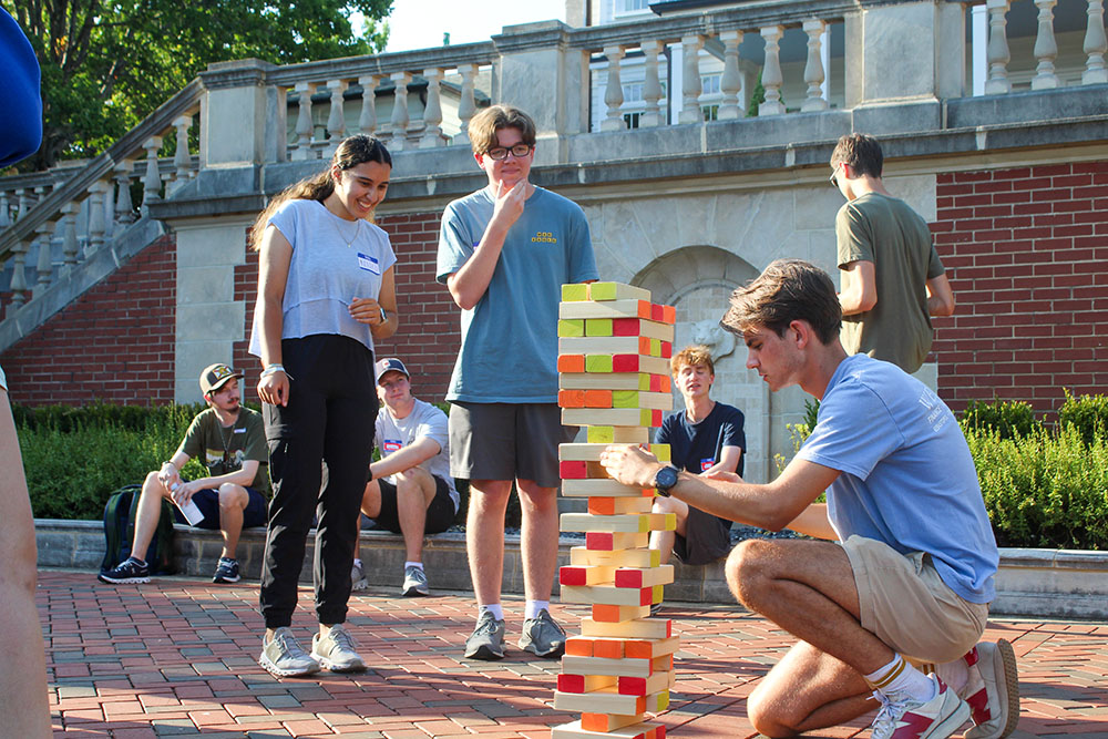 students at the back of Cater Hall playing giant jenga on a bright sunny day