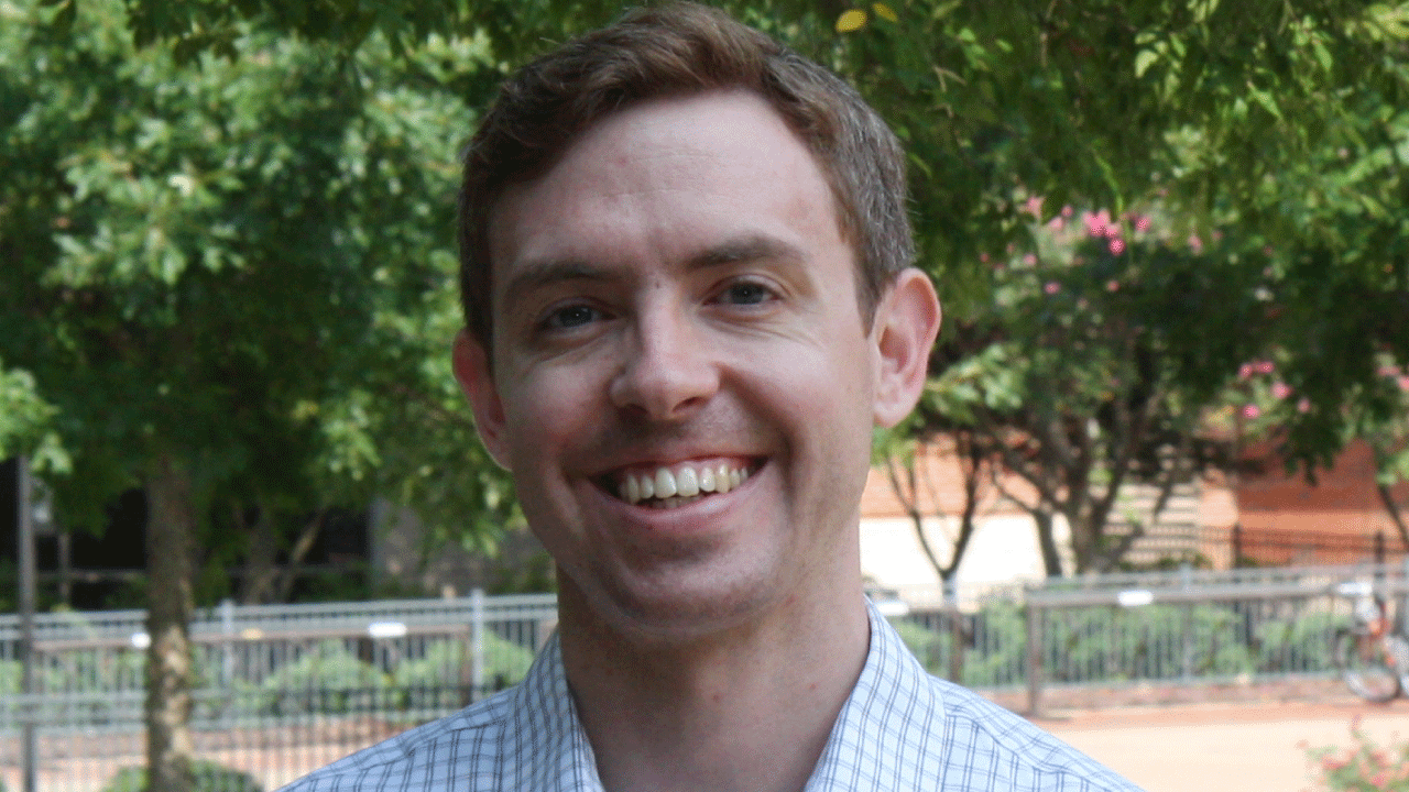 close up headshot of Dr. Ben Fagan, Ben is smiling and wearing a light blue plaid collared shirt