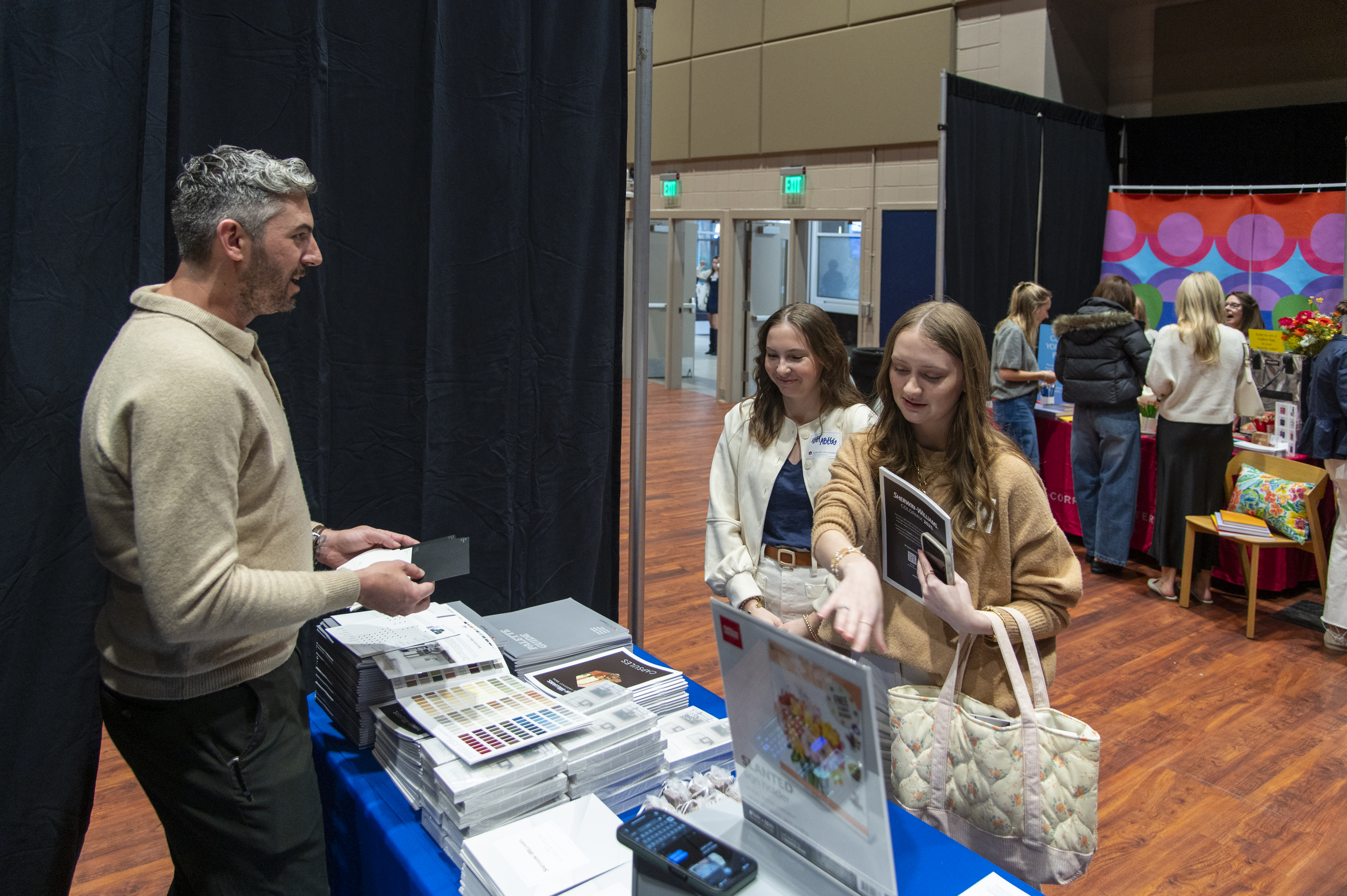 Students speak with a company representative at the INDS Product Fair