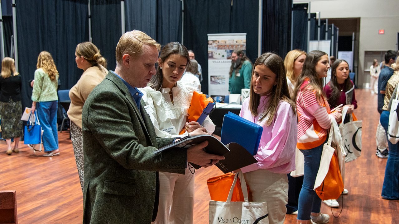 Students speak with a company representative at the INDS Product Fair