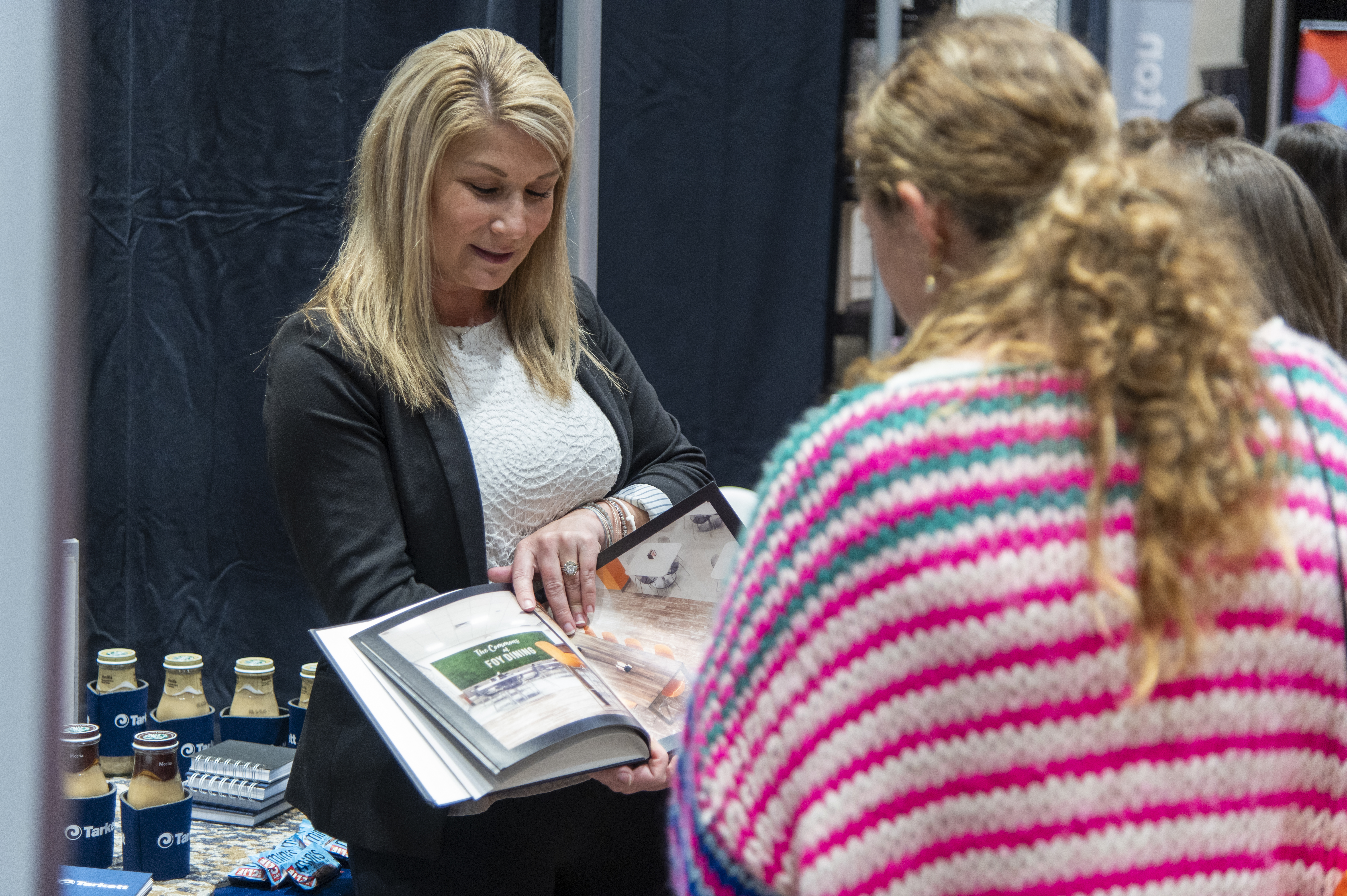 Students speak with a company representative at the INDS Product Fair