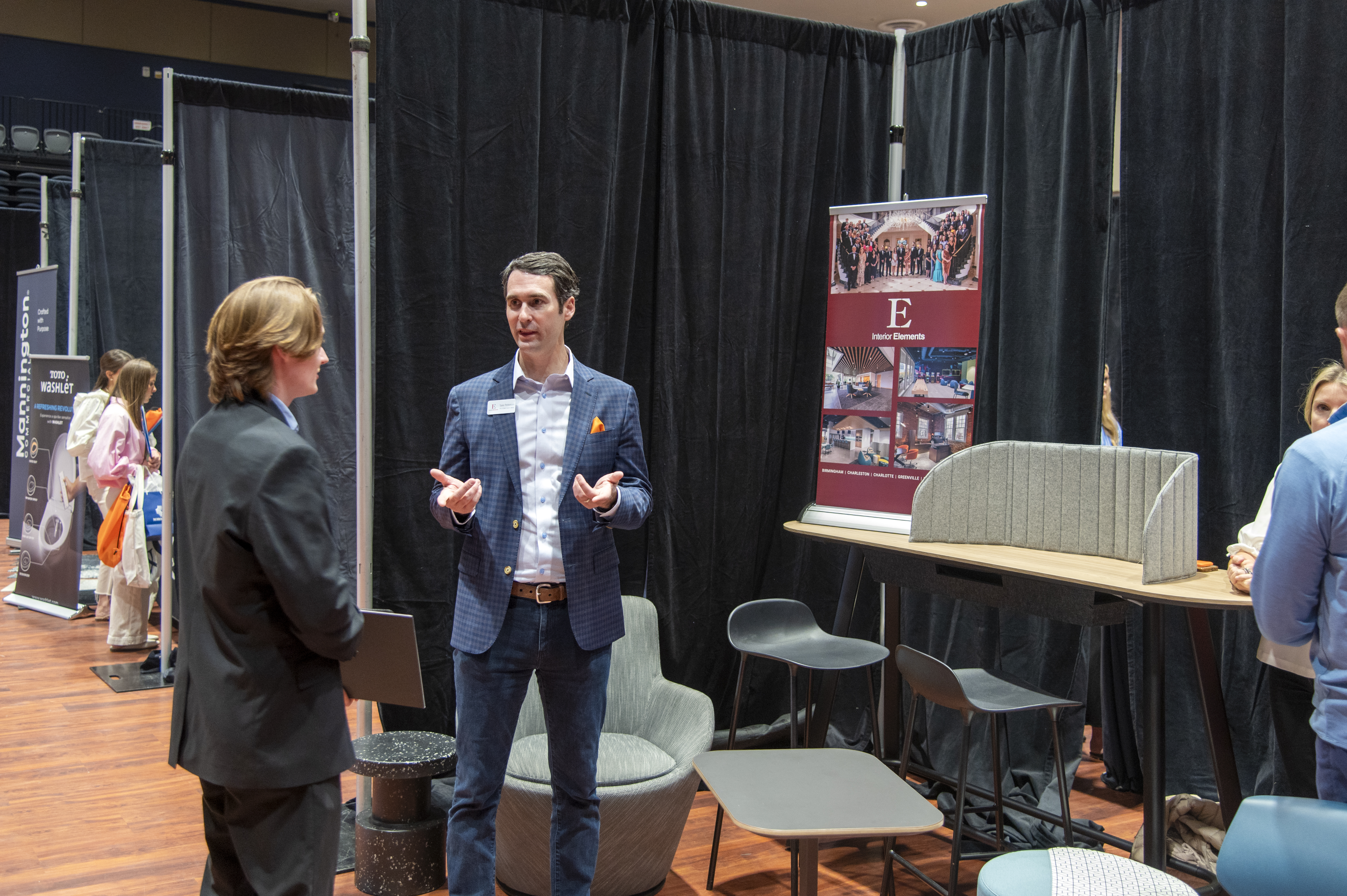 Students speak with a company representative at the INDS Product Fair