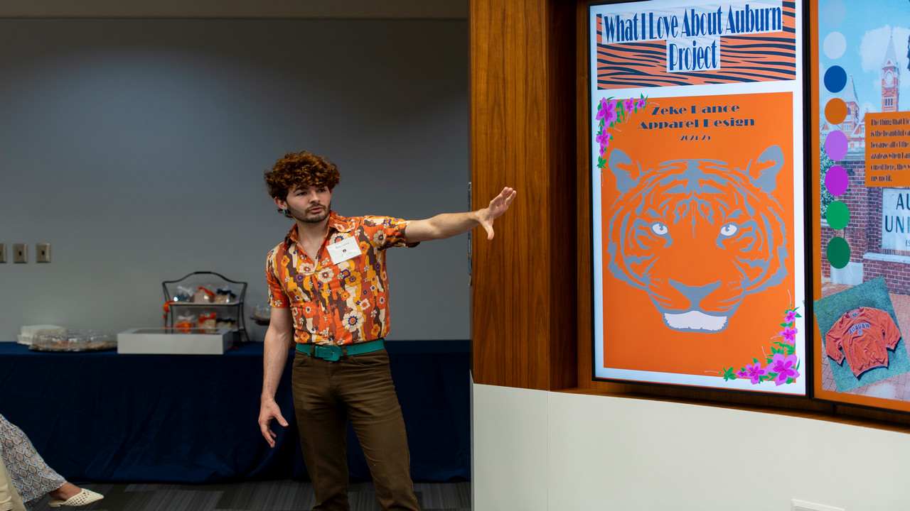 Zeke Dance, a sophomore majoring in apparel design and production management, shows off his creation for the Design Challenge.