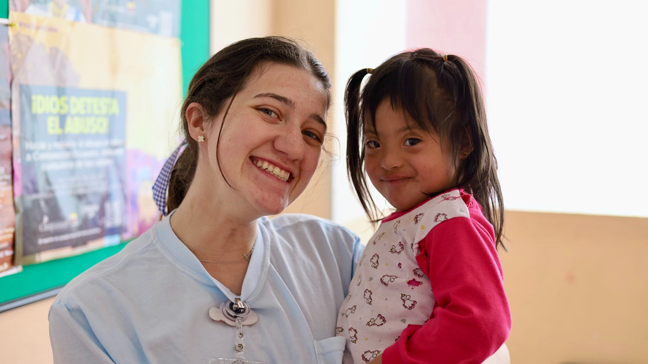 Emma Lowell, pictured with a child as she received her bachelor's degree in human development and family science (HDFS) in the child life option.